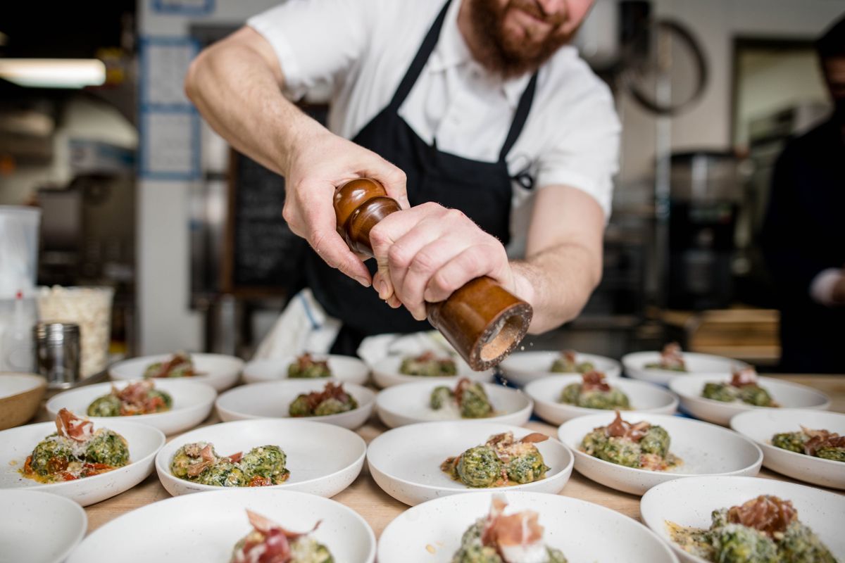 A focused restaurant kitchen line plating a small number of dishes well