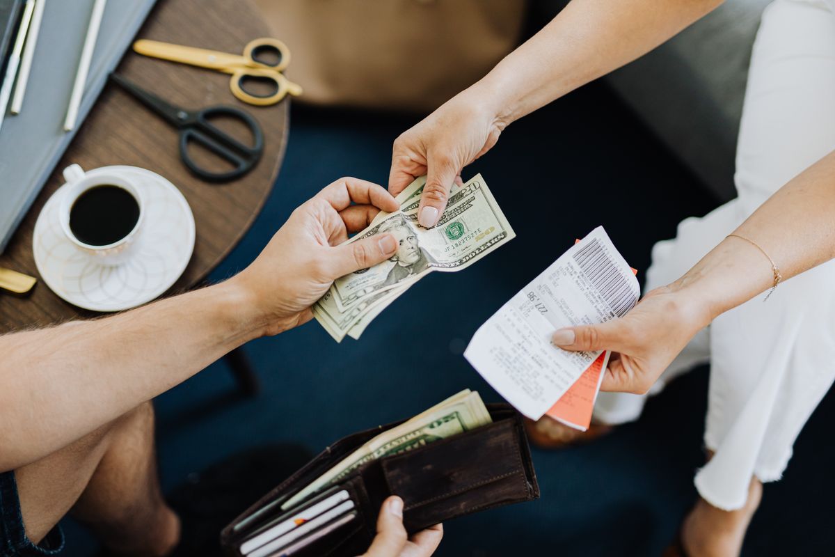 Cash and a receipt being handled over a café table