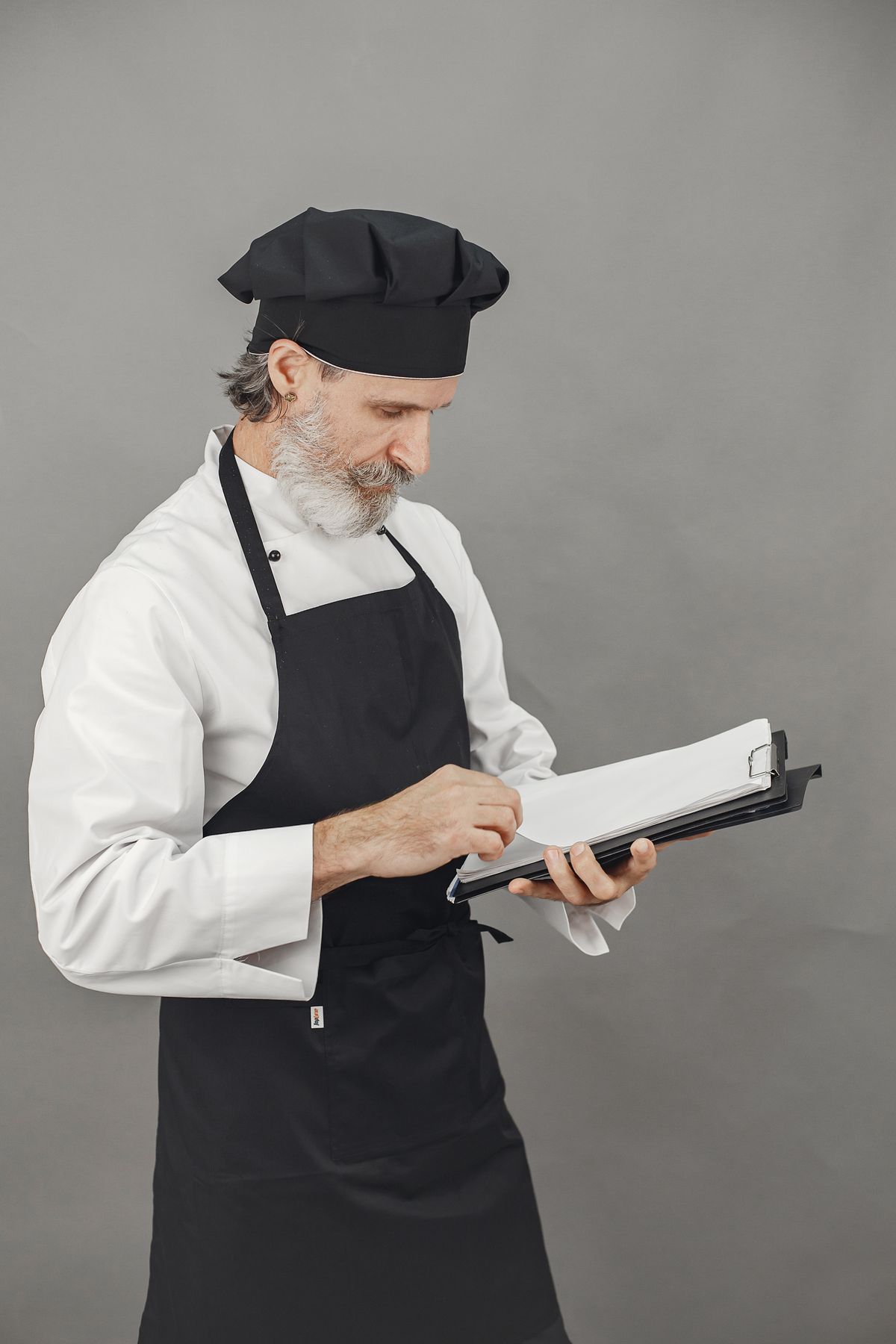 A chef reviewing stock records on a clipboard