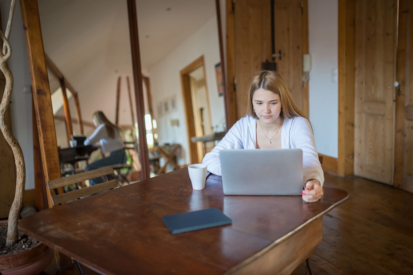 A café owner updating their restaurant's own website on a laptop
