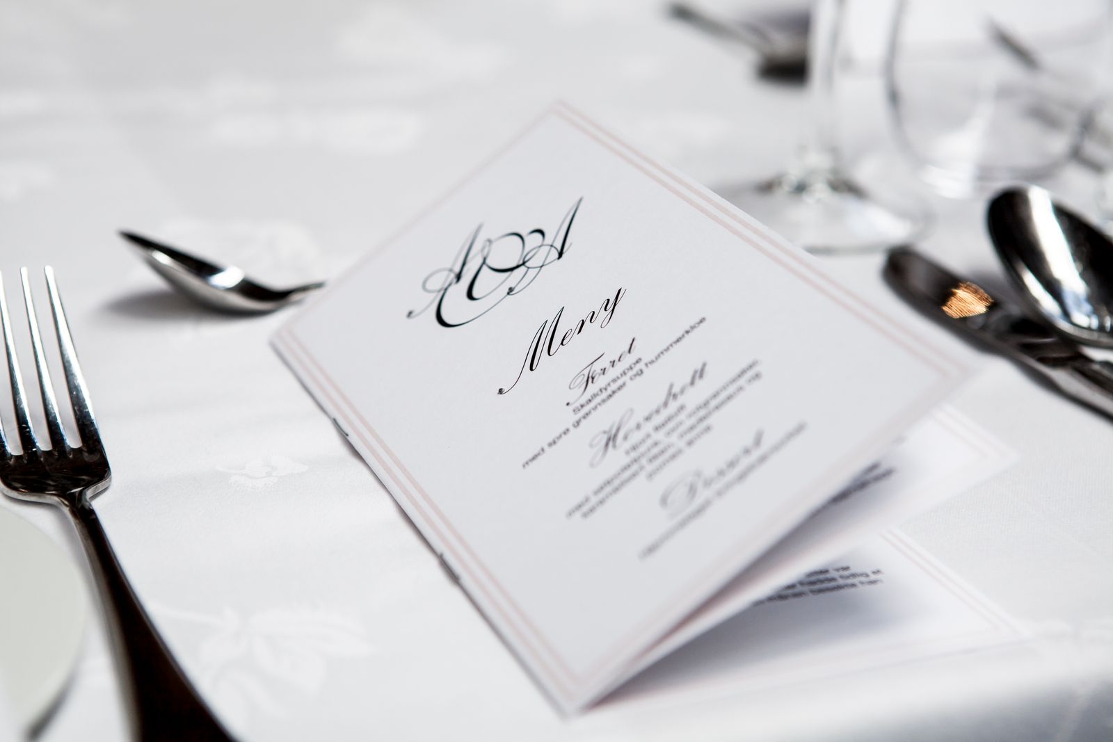 An elegant menu card resting on a set restaurant table