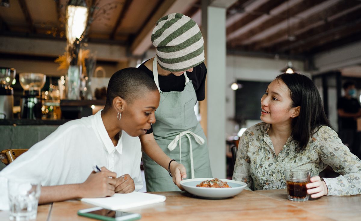A senior staff member showing a dish to two colleagues
