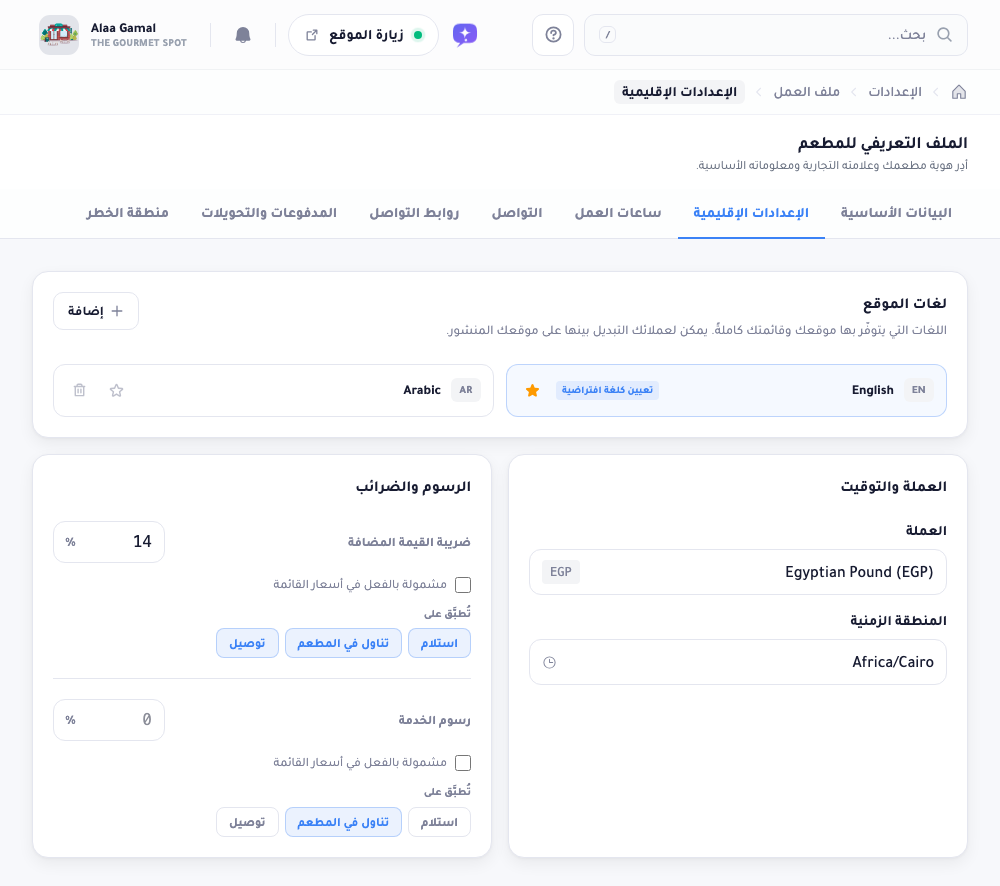 تبويب الإعدادات الإقليمية: بطاقة لغات الموقع وبها نجمة الافتراضي لكل لغة، بطاقة العملة والتوقيت، وبطاقة الرسوم والضرائب بضريبة القيمة المضافة ورسوم الخدمة.